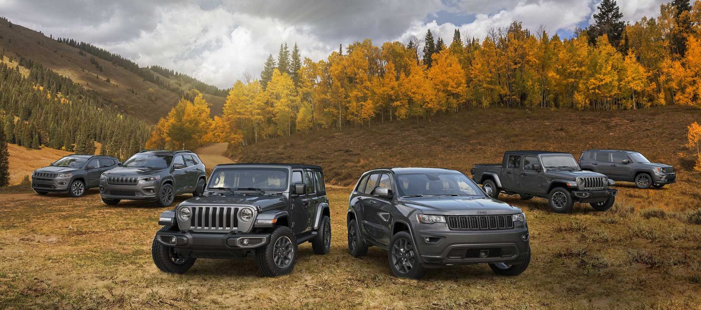 The 2021 80th Anniversary Jeep Brand lineup parked on a grassy autumn terrain, front row: Wrangler 80th Anniversary, Grand Cherokee 80th Anniversary and back row: Compass 80th Anniversary, Cherokee 80th Anniversary, Gladiator 80th Anniversary, Renegade 80th Anniversary.